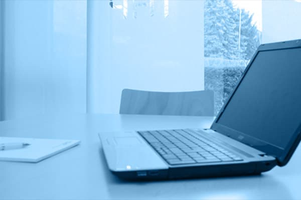 Laptop auf einem Besprechungstisch in blauem Licht